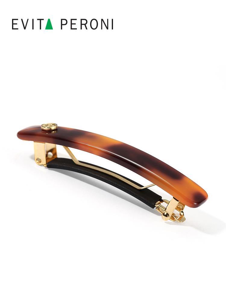 Elegant tortoiseshell barrette hair clip with gold details on white background