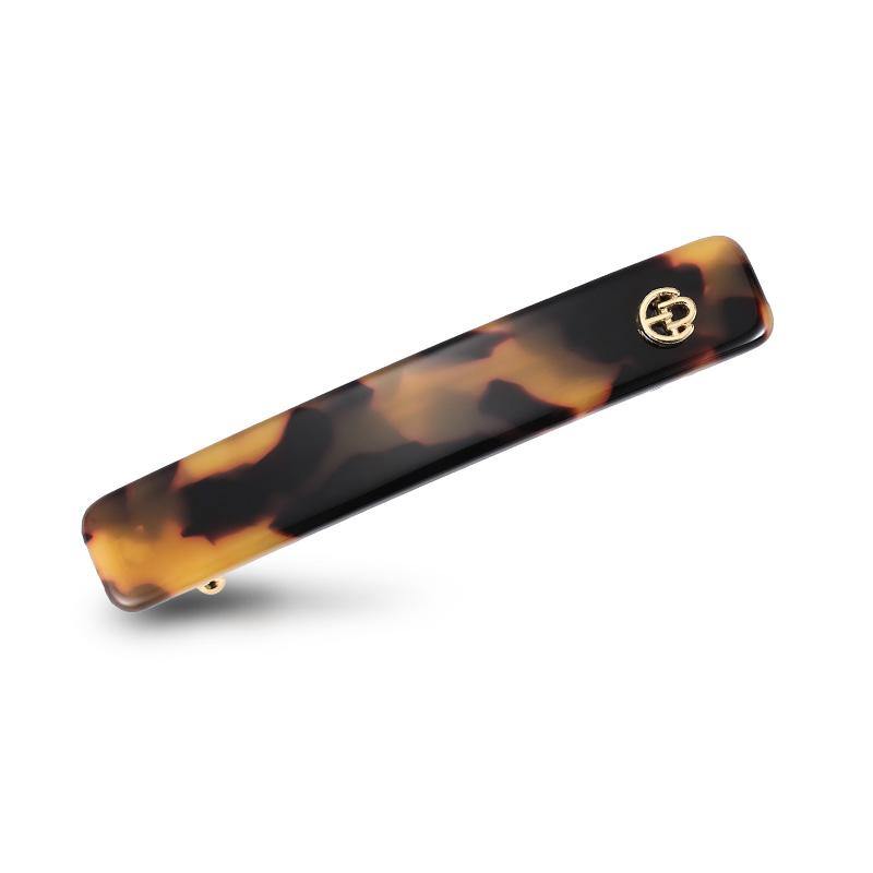 Tortoiseshell rectangular hair barrette with gold accent on white background