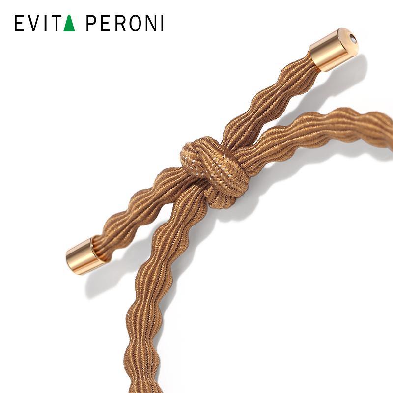 Elegant brown braided hair tie with gold-tone metal tips on white background